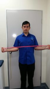 Image of a man doing shoulder exercise with theraband