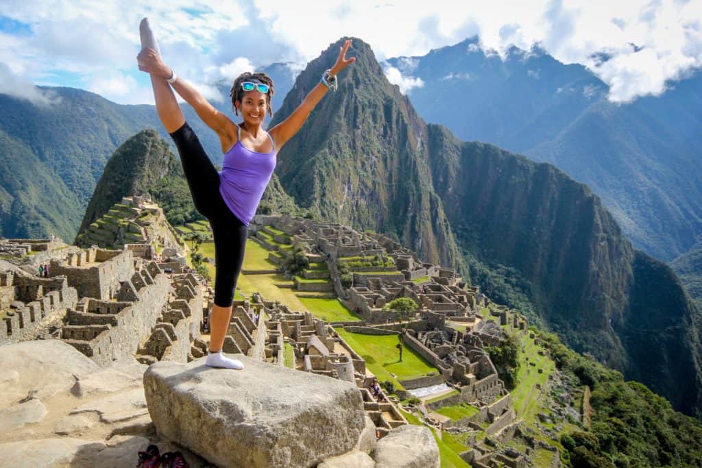 picture of a woman in a yoga pose at the top of a mountain