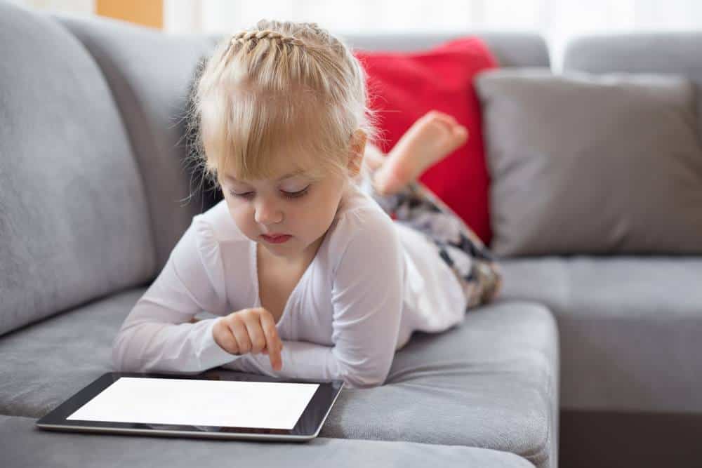 picture of a girl lying on the couch with a tablet