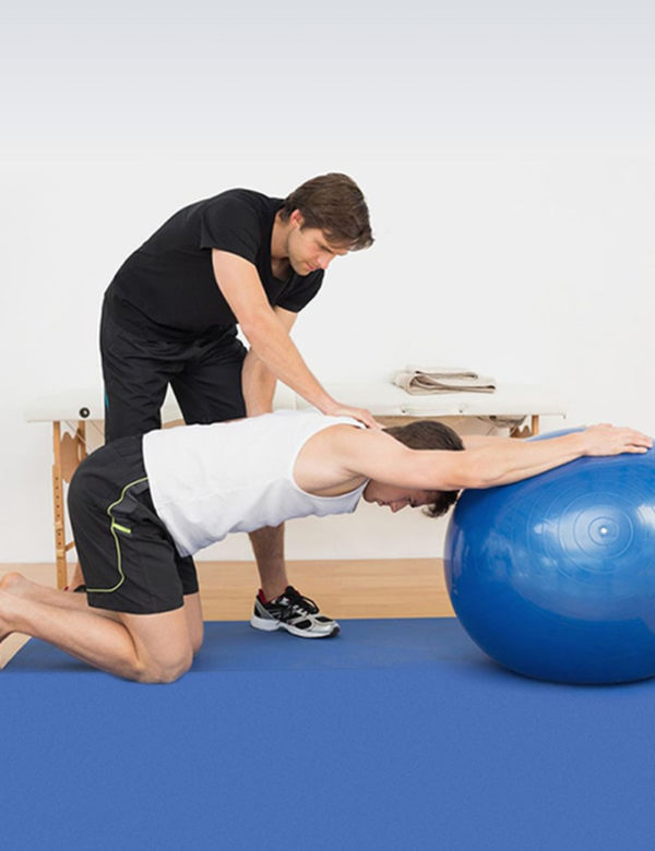 Picture of a therapist showing exercise with a gym ball