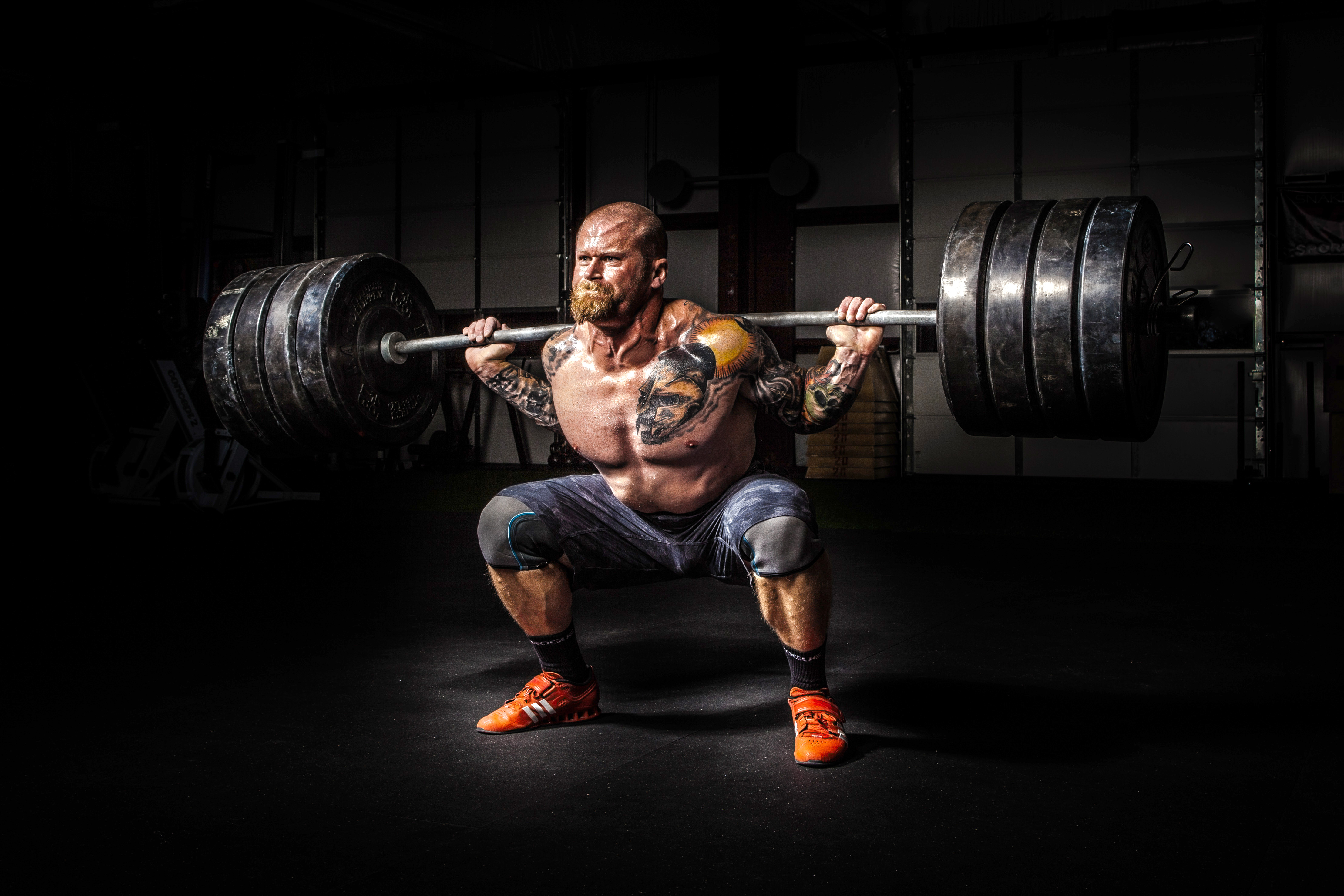 man squatting with a barbell