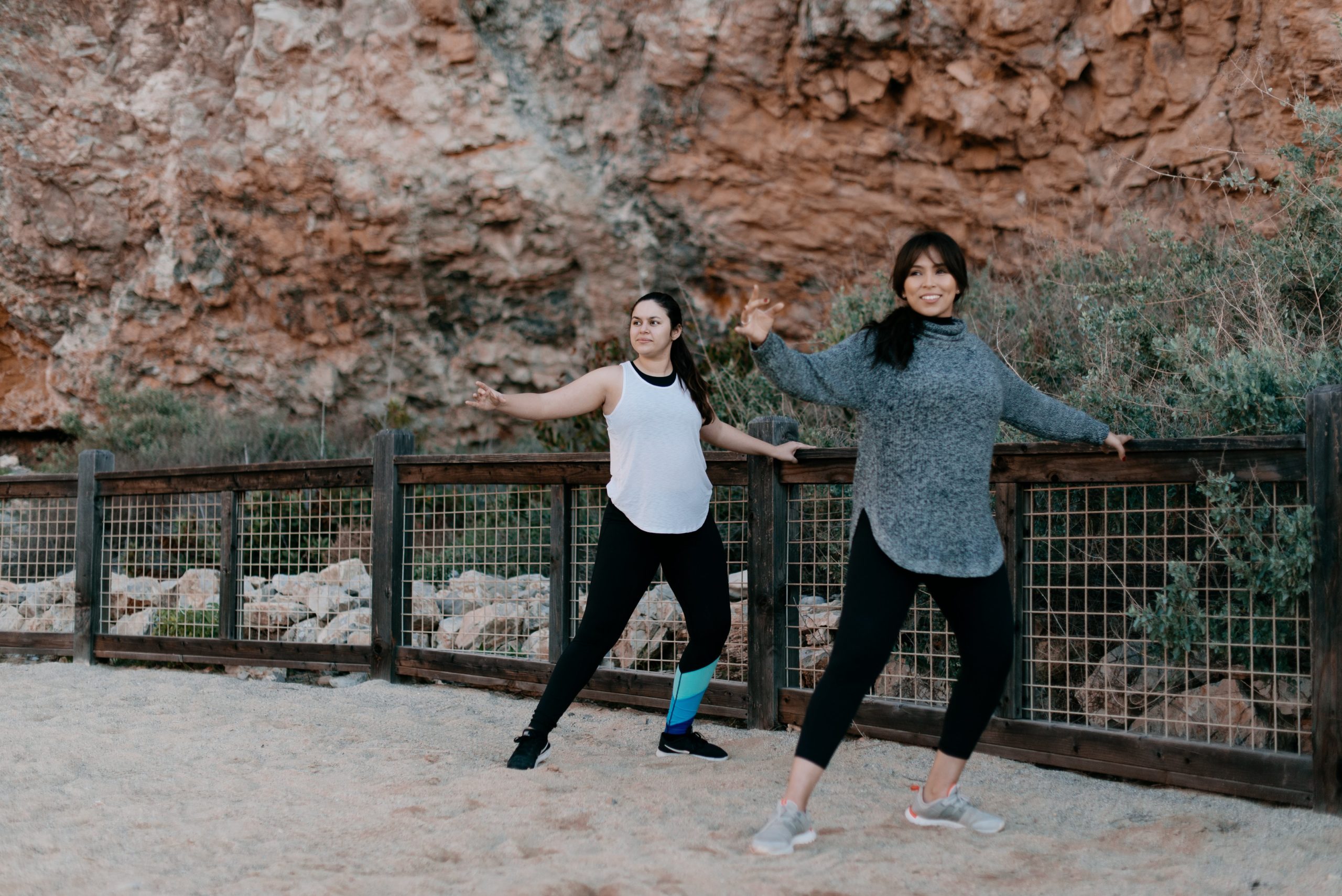 two-women-warming-up-on-the-beach woman exercising on a cross trainer