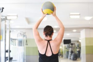 How our Physios fix rotator cuff pain? 1 woman lifting overhead