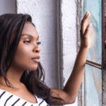 young woman gazing out of a rustic window
