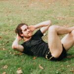 man lying on the grass doing crunches