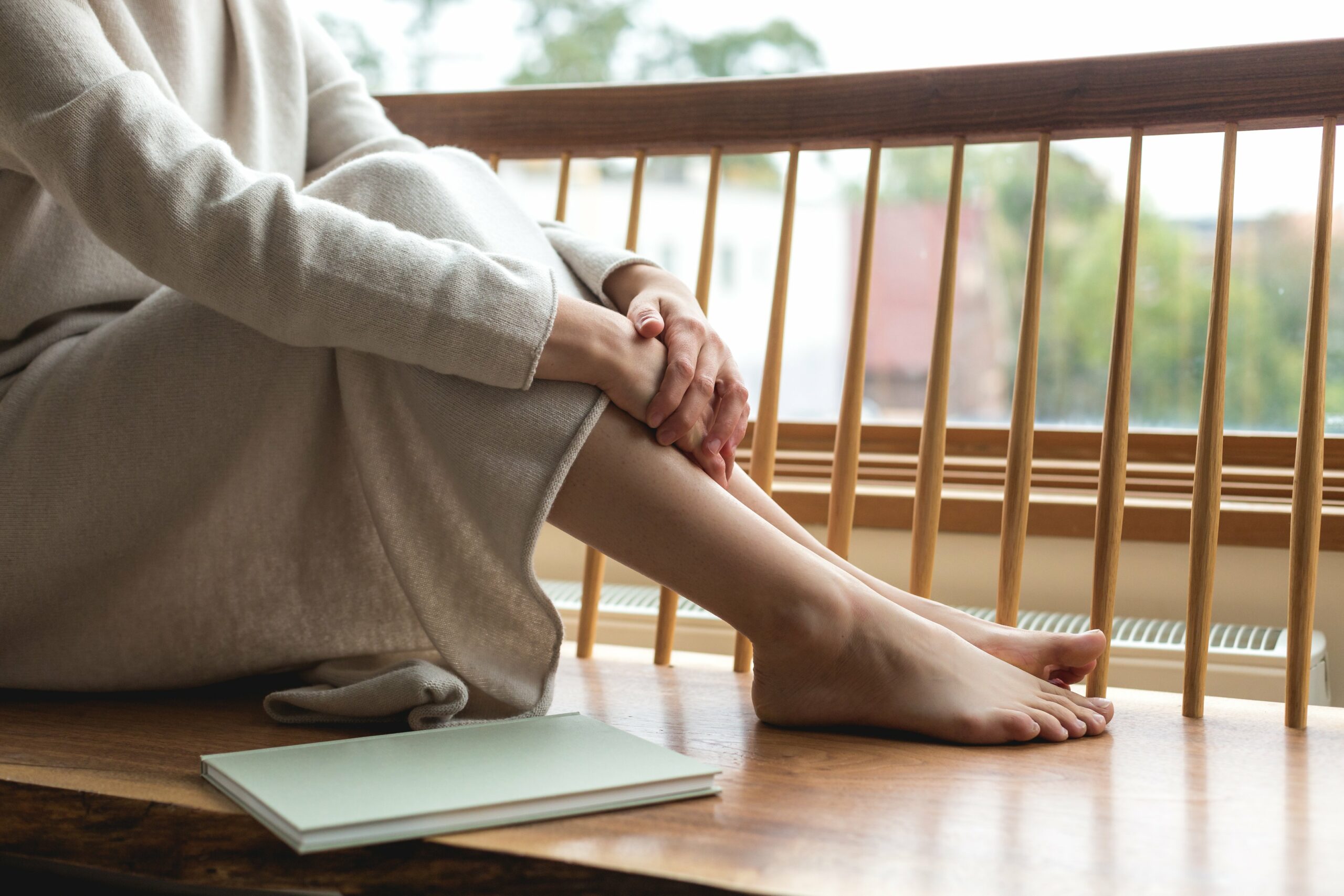 woman resting her feet by the window scaled