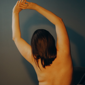 A woman in her postpartum body doing stretches