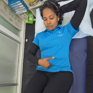 Postpartum woman performing a gentle diastasis recti self-check